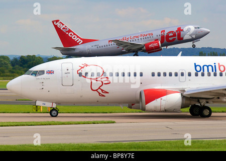 Ein Flugzeug startet als eine andere Taxis zum Terminal. Stockfoto