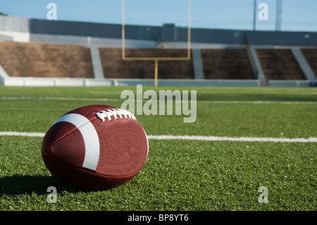US-amerikanischer American-Football auf Feld mit Torpfosten im Hintergrund. Stockfoto