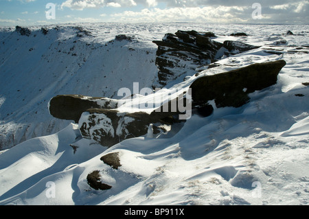 Erodierten Felsen und Schnee driftet auf Kinder Scout Plateau, Peak District, Derbyshire, England, UK Stockfoto