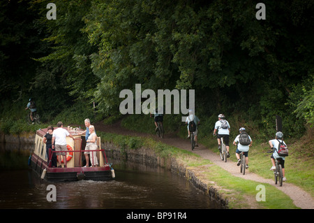 Radfahrer auf dem Leinpfad und einem Narrowboat Monmouthshire und Brecon Canal, South Wales UK Stockfoto