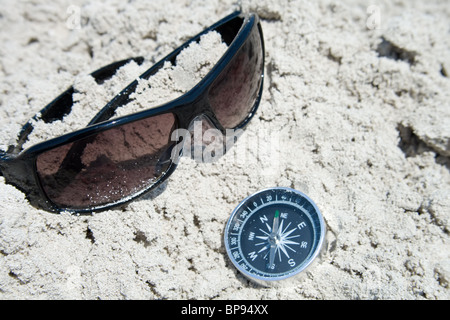 Sonnenbrillen und Kompass im sand Stockfoto