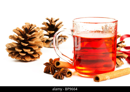 roter Tee in ein Glas, Zimtstangen, Sternanis und einige Nadelbaum Zapfen auf weißem Hintergrund Stockfoto