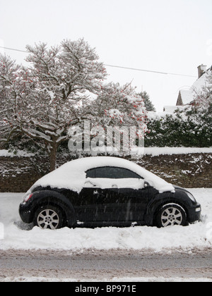 Ein VW-Beetle Cabriolet Auto im dicken Schnee auf einer Straße in Fès, Gloucestershire, England, UK. Stockfoto