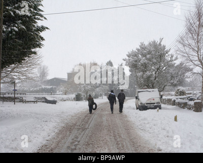 Dick Schnee und Kinder gehen auf die Straße in den Cotswolds Stockfoto