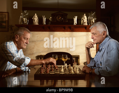 Zwei Senioren genießen Sie am Abend eine Partie Schach Stockfoto