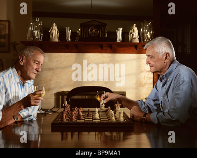 Zwei Senioren genießen Sie am Abend eine Partie Schach Stockfoto