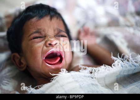 Ein kleines Kind weint laut in einem Waisenhaus für Waisen und Kinder AIDS von einer lokalen NGO in Chennai, Südindien. Stockfoto