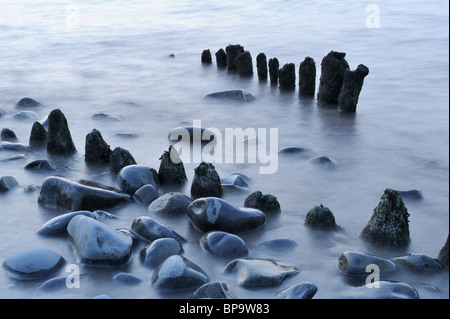 Ein Auszug aus Steinen und Holz Buhnen am Lilstock Strand, Somerset. Eine lange Verschlusszeit verursacht das Wasser zu stark verschwimmen. Stockfoto