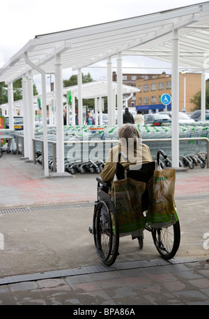 Alte Frau im Rollstuhl bei Asda auf Hilfe warten Stockfoto