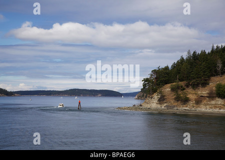 Eine Motoryacht gibt eine Navigation-Markierung am Südende der Insel Blakely weiter. San Juan Islands, Washington Stockfoto