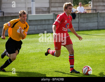 Warrington Stadt Spieler rennt mit dem Ball von einem Spieler Ossett Albion an der Dimplewells Road in Ossett gemahlen Stockfoto