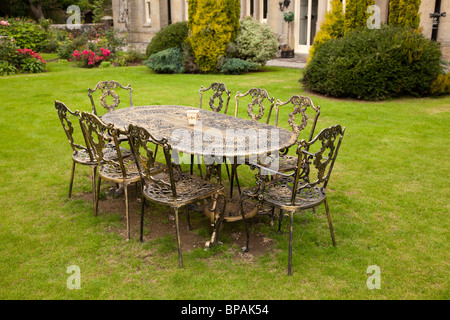 Altmodische gold farbigen Gusseisen Tisch mit acht Stühlen auf formale Rasen Stockfoto