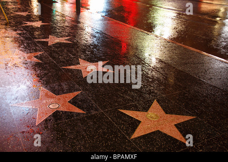 Hollywood Walk of Fame Boulevard nass mit Regen und Reflexionen in der Nacht Stockfoto