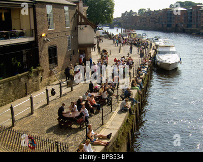 Das Flussufer in Kings Staith ist voll mit Menschen, die die Sommersonne genießen. York River Ouse. Stockfoto