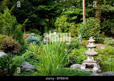 Japanischer Zen-Garten für Meditation und Entspannung, gefüllt mit grüner Vegetation und Granit Rokkaku Yukimi Laternen verwendet. Stockfoto