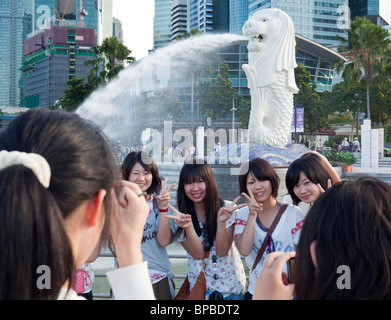 Chinesische Touristen fotografieren vor der Merlion, das Wahrzeichen von Singapur Stockfoto