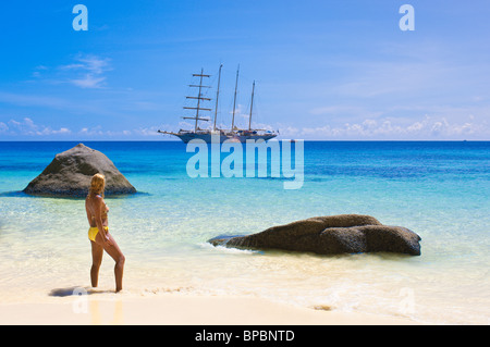 Frau im Bikini am Strand mit star Flyer Klipper vor Ko Miang Insel Similan Inseln in der Andaman Sea, Thailand verankert. Stockfoto