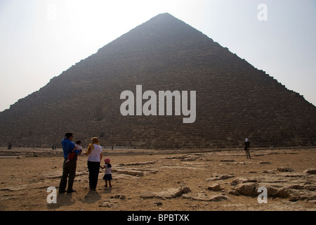 Touristen stehen vor den Pyramiden von Gizeh mit der Sonne hinter den Bau Stockfoto