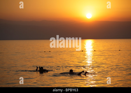 Menschen schweben im Toten Meer bei Sonnenuntergang, Jordanien Stockfoto