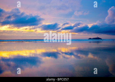 Godrevy bei Sonnenuntergang; mit Reflexionen im nassen Sand; Cornwall Stockfoto