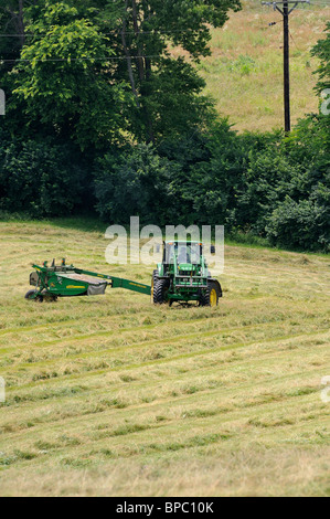 Traktor-schneiden-Heu in einem Feld in Kentucky, USA Stockfoto