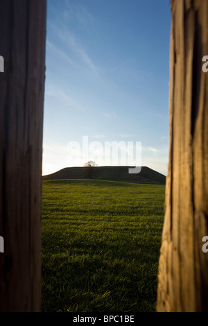 Blick durch die hölzerne Palisade in Richtung Mönche Hügel bei Sonnenuntergang, Cahokia Mounds State Historic Site, Illinois, USA. Stockfoto