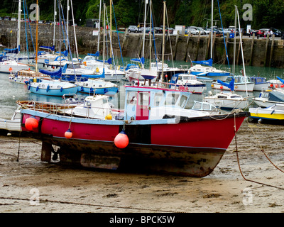 Eine rote geschälten Fischerboot liegt auf dem kleinen Strand in Ilfracombe Hafen bei Ebbe Stockfoto