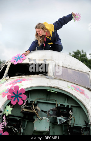 Ein Künstler schmückt ein altes Flugzeug der RAF mit Blumen in The Trash Stadtgebiet auf dem Glastonbury Festival-Gelände Pilton UK Stockfoto