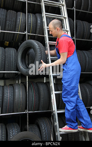 Ein motivierter Arbeiter in einer Reifen Werkstatt Auffüllen der Ware. Stockfoto