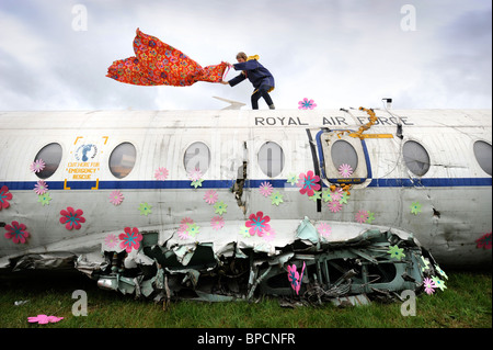 Ein Künstler schmückt ein altes Flugzeug der RAF mit Blumen in The Trash Stadtgebiet auf dem Glastonbury Festival-Gelände Pilton UK Stockfoto