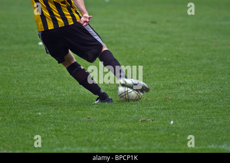 Fußballspieler in schwarz-gelben Uniform den Ball. Horizontale Stockfoto