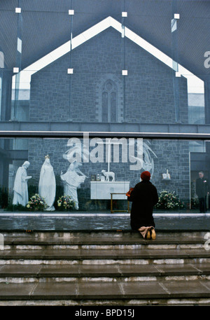 Pilgrim kniet und betet vor religiösen Schrein in Knock, Irland Stockfoto