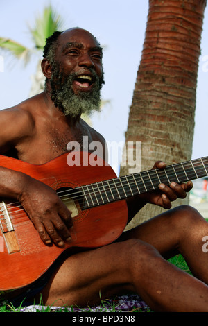 Alter Schwarzer Mann Gitarre spielen auf einer tropischen Insel. Stockfoto