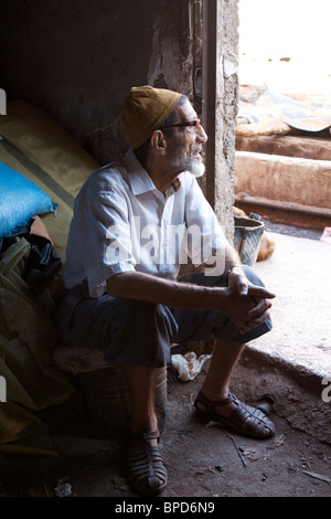 Ein alter Mann nimmt eine Pause von der Arbeit an der Gerbereien, Marrakesch, Marokko, Nordafrika Stockfoto