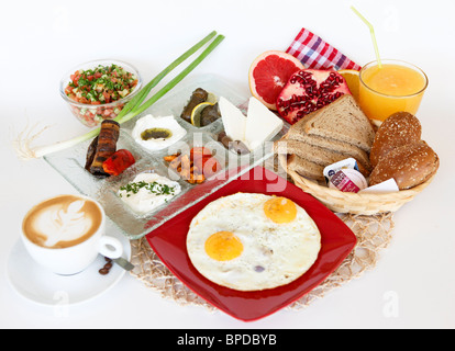 Traditionelle israelisches Frühstück mit zwei Spiegeleier, Käse, Salat, roll ein frischen Orangensaft und eine Tasse cappuccino Stockfoto