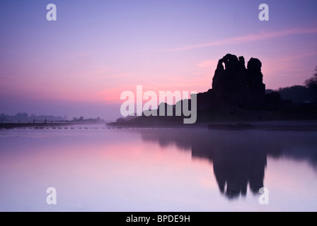 Sonnenaufgang über dem Ogmore Schloss an einem ruhigen nebligen Frühlingsmorgen. Stockfoto