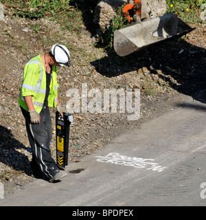 Straßenbau M25 Autobahnarbeiter mit harten Schultern, der Handgeräte zur Ortung von Scopes und Kabeln verwendet, bevor der Bagger mit der Arbeit beginnt Brentwood Essex England Großbritannien Stockfoto