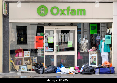 Spenden Links auf den Bürgersteig außerhalb Oxfam Shop Fenster & Tür vor der Eröffnung Zeit High Street Brentwood Essex England Großbritannien Stockfoto