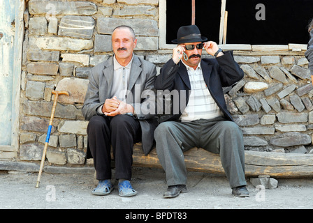 Aserbaidschan, Xinaliq, Porträt von reifer Mann, sitzend mit senior woman nebeneinander gegen Steinmauer Stockfoto