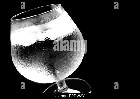 Kaltes Wasser mit Eiswürfeln in einem Glas, Nahaufnahme Studio vor schwarzem Hintergrund Stockfoto