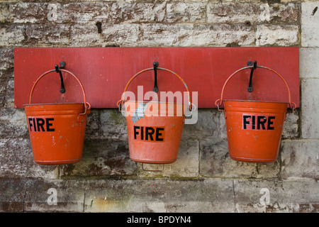 Eine Reihe von drei roten Feuer Eimer am Bahnhof Corfe Castle, Dorset Stockfoto