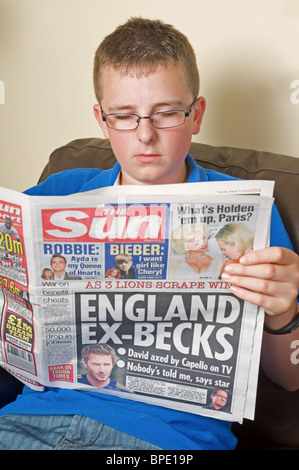 Teenager, die eine Kopie der Sonne Zeitung lesen Stockfoto