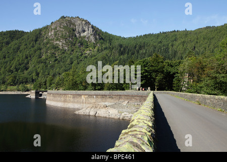 Die Thirlmere Damm mit Raven Crag einen Spitzenwert von Wainwright und bewaldeten Hügel darüber. Stockfoto