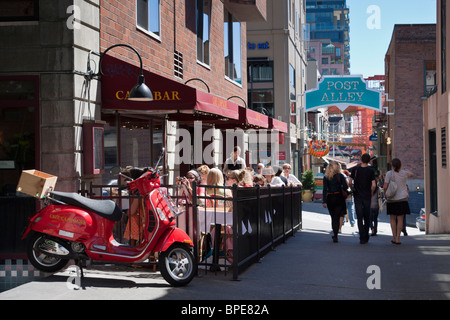 Rote Vespa GTS-250 parkte neben Gastgarten Campagne Cafe, Pike Place Market, Seattle, Washington Stockfoto