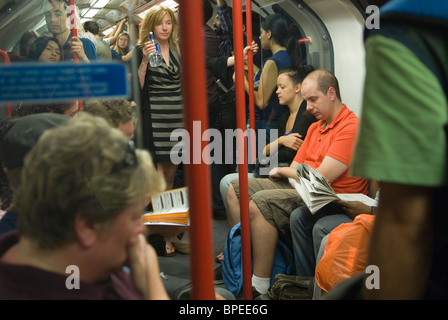 Überfüllte Londoner U-Bahn-Leute Passagiere Touristen, die mit der U-Bahn reisen. Müde Menschen, tote und erschöpfte Frau mit einer Flasche Wasser England 2010 2010er Jahre UK HOMER SYKES Stockfoto