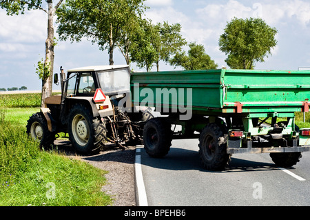 Traktor auf der Straße im Sommer, Ernte Stockfoto
