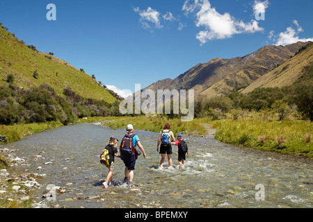 Familie von Wanderer Kreuzung Moke Creek, Moonlight-Track, in der Nähe von Queenstown, Südinsel, Neuseeland Stockfoto