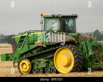 John Deere Kautschuk verfolgt Traktor in einem kürzlich geernteten Maisfeld bereit zum Pflügen der Erde aufbrechen Stockfoto