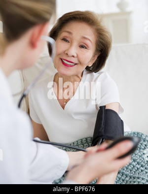 Arzt überprüft Blutdruck des Patienten Stockfoto