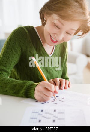 Japanische Frau Kreuzworträtsel zu lösen Stockfoto